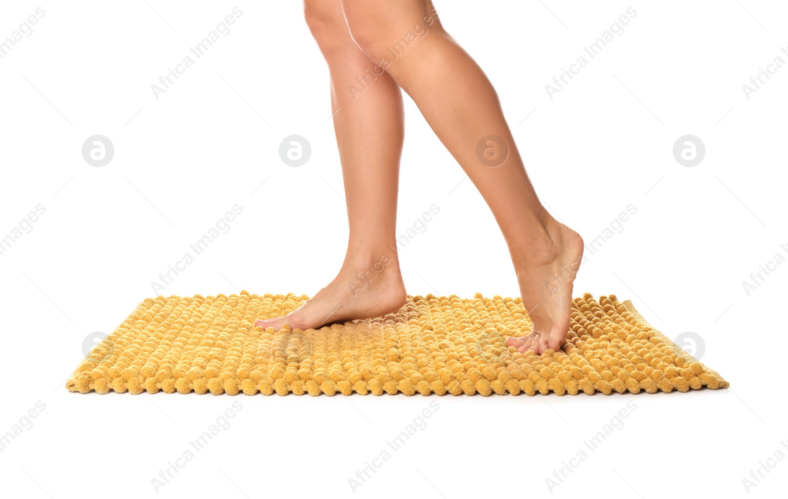 Photo of Woman standing on soft orange bath mat against white background, closeup