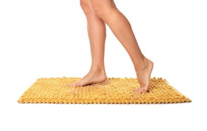 Woman standing on soft orange bath mat against white background, closeup