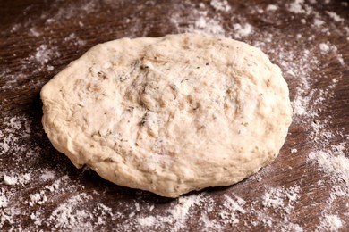 Photo of Fresh dough on wooden table, closeup. Cooking grissini
