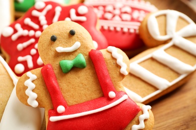 Photo of Tasty homemade Christmas cookies on wooden plate, closeup view