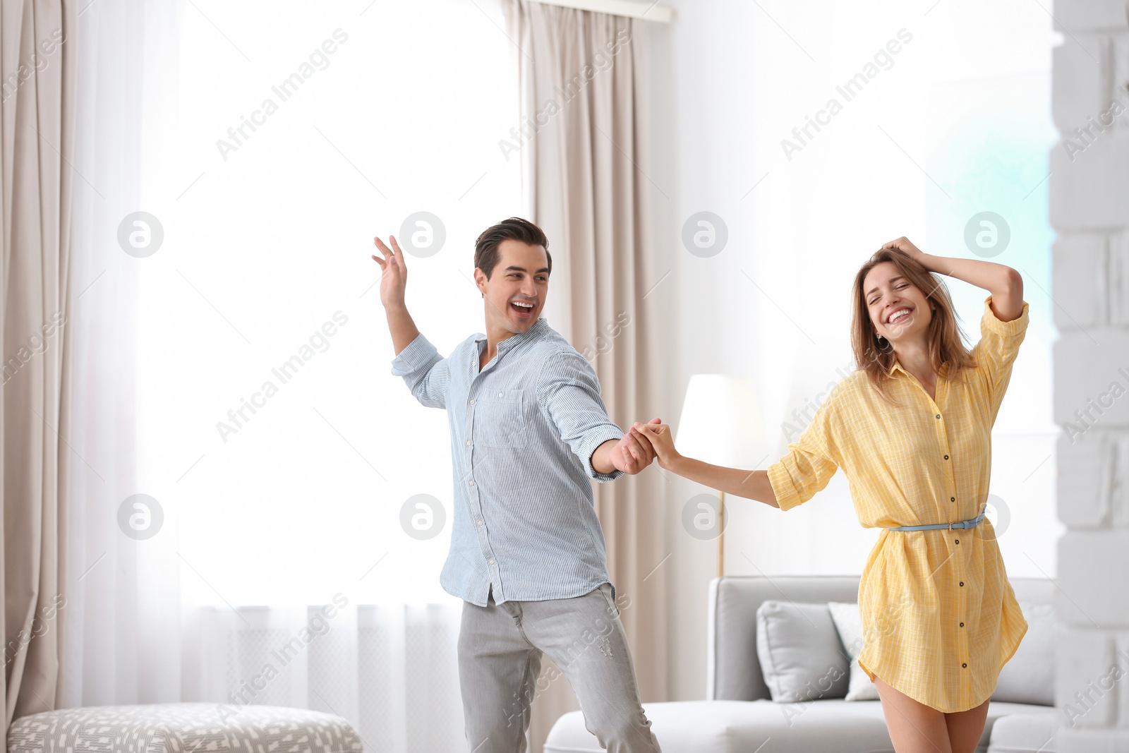 Photo of Beautiful young couple dancing in living at home