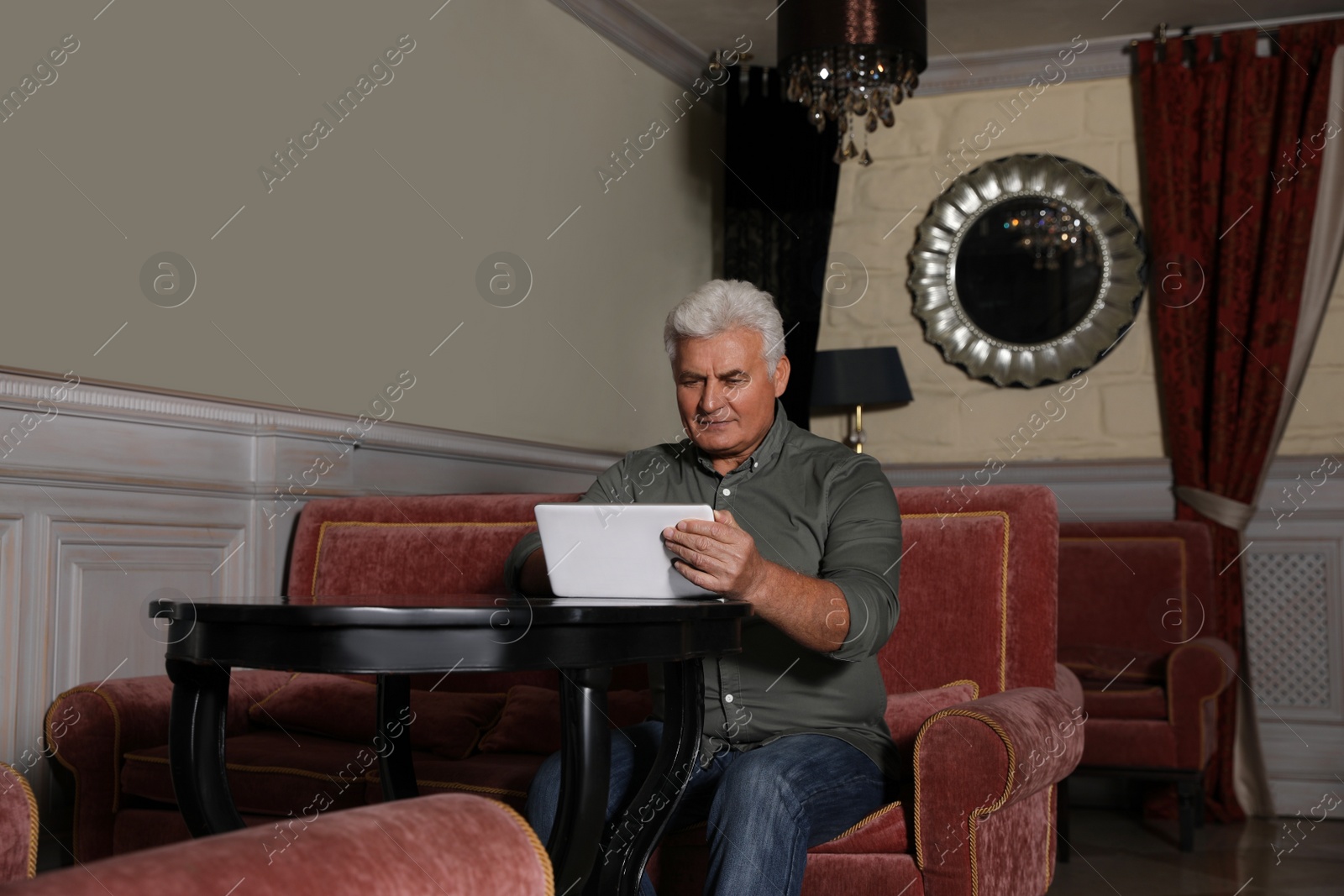 Photo of Senior business owner with tablet in his restaurant