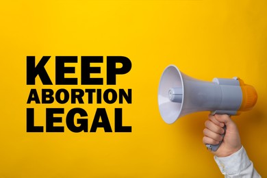 Image of Man with megaphone involved in reproductive rights protest, closeup. Slogan Keep Abortion Legal on yellow background