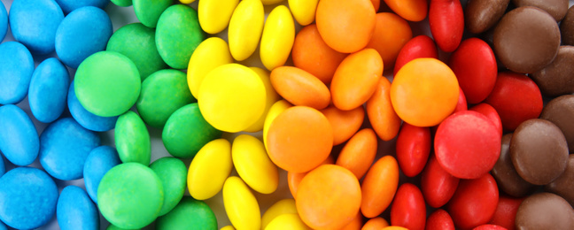 Many colorful candies as background, top view. Banner design 