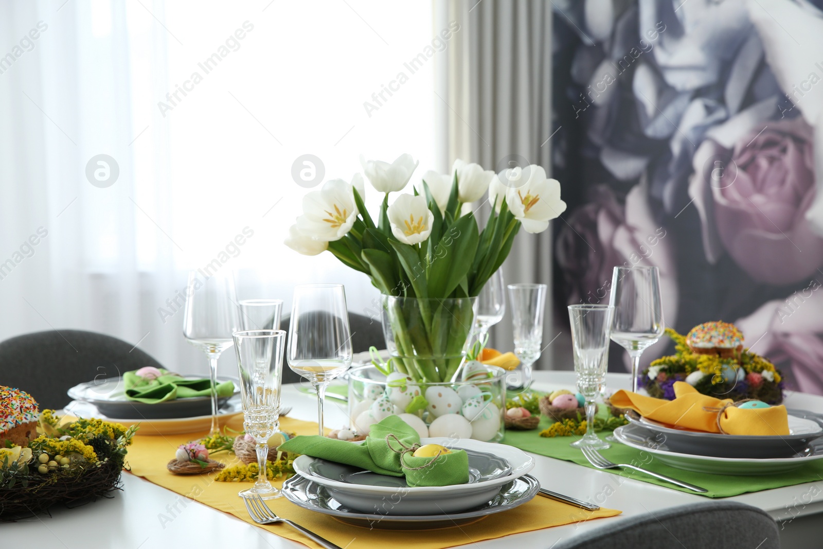 Photo of Festive Easter table setting with beautiful white tulips and eggs indoors