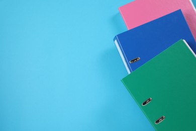 Photo of Many office folders on light blue background, flat lay. Space for text