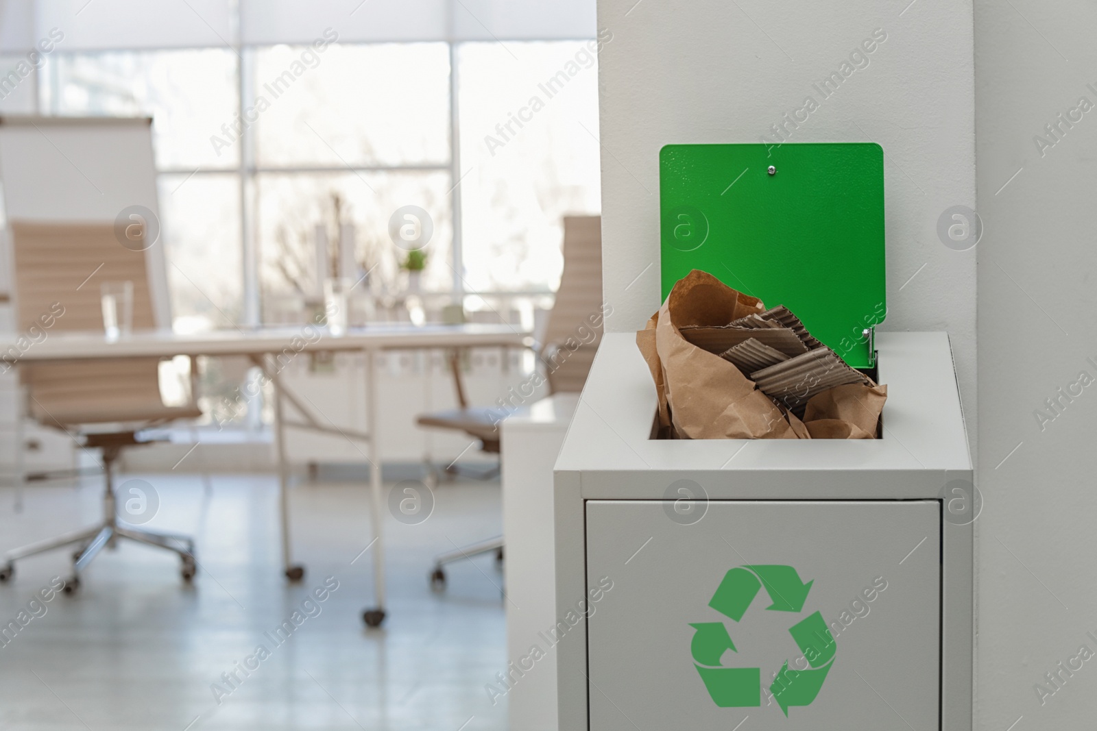 Photo of Open full trash bin in modern office, space for text. Waste recycling