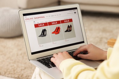 Photo of Woman shopping online during sale on laptop at home, closeup