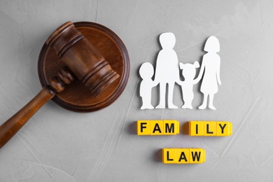 Flat lay composition with figure and gavel on grey background. Family law concept