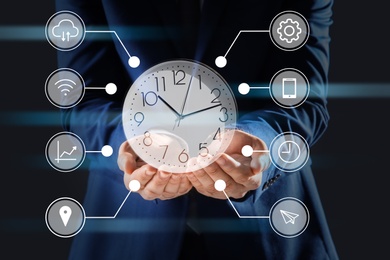 Image of Time management concept. Man with clock surrounded by icons, closeup