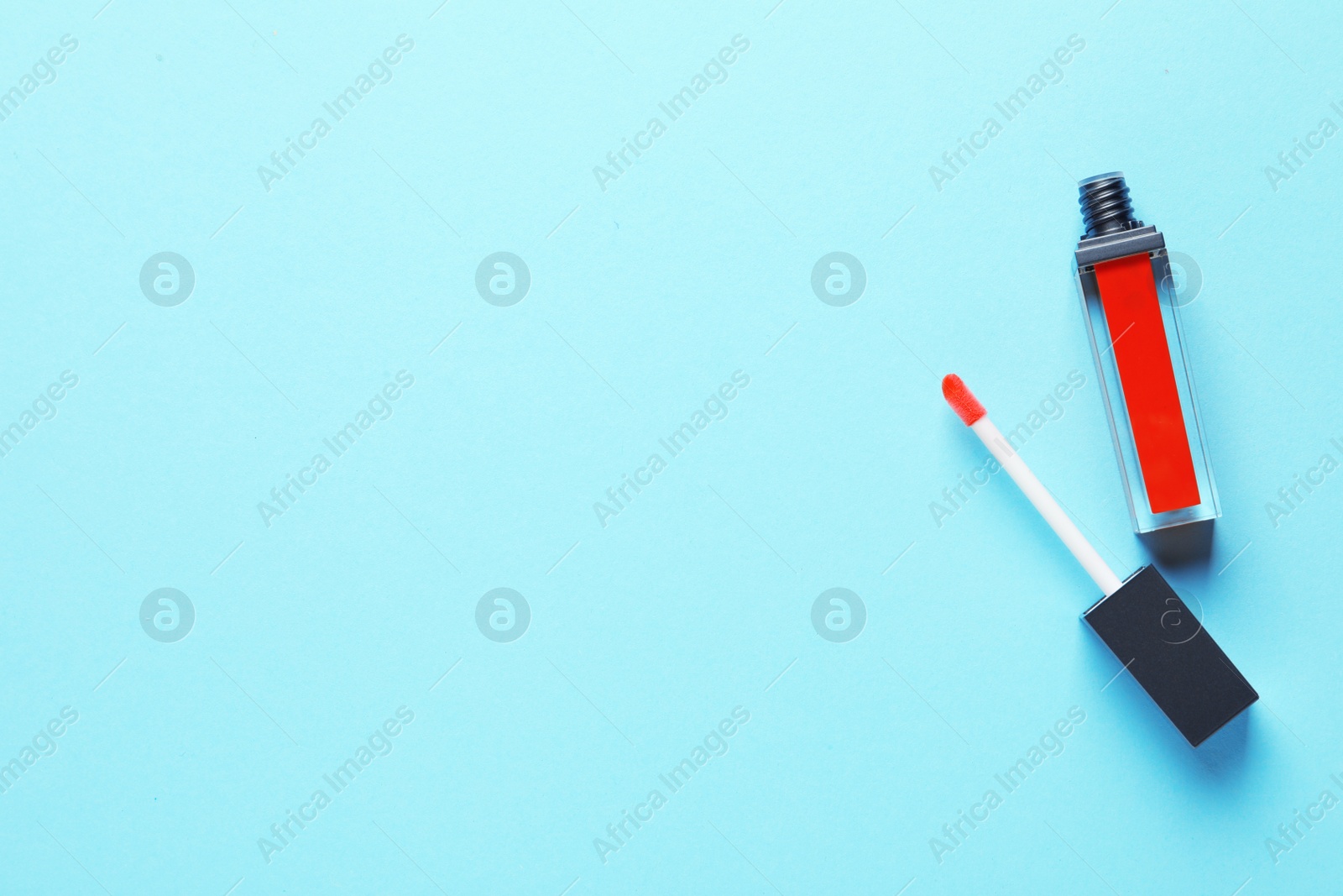 Photo of Applicator and liquid lipstick tube on color background, flat lay. Space for text