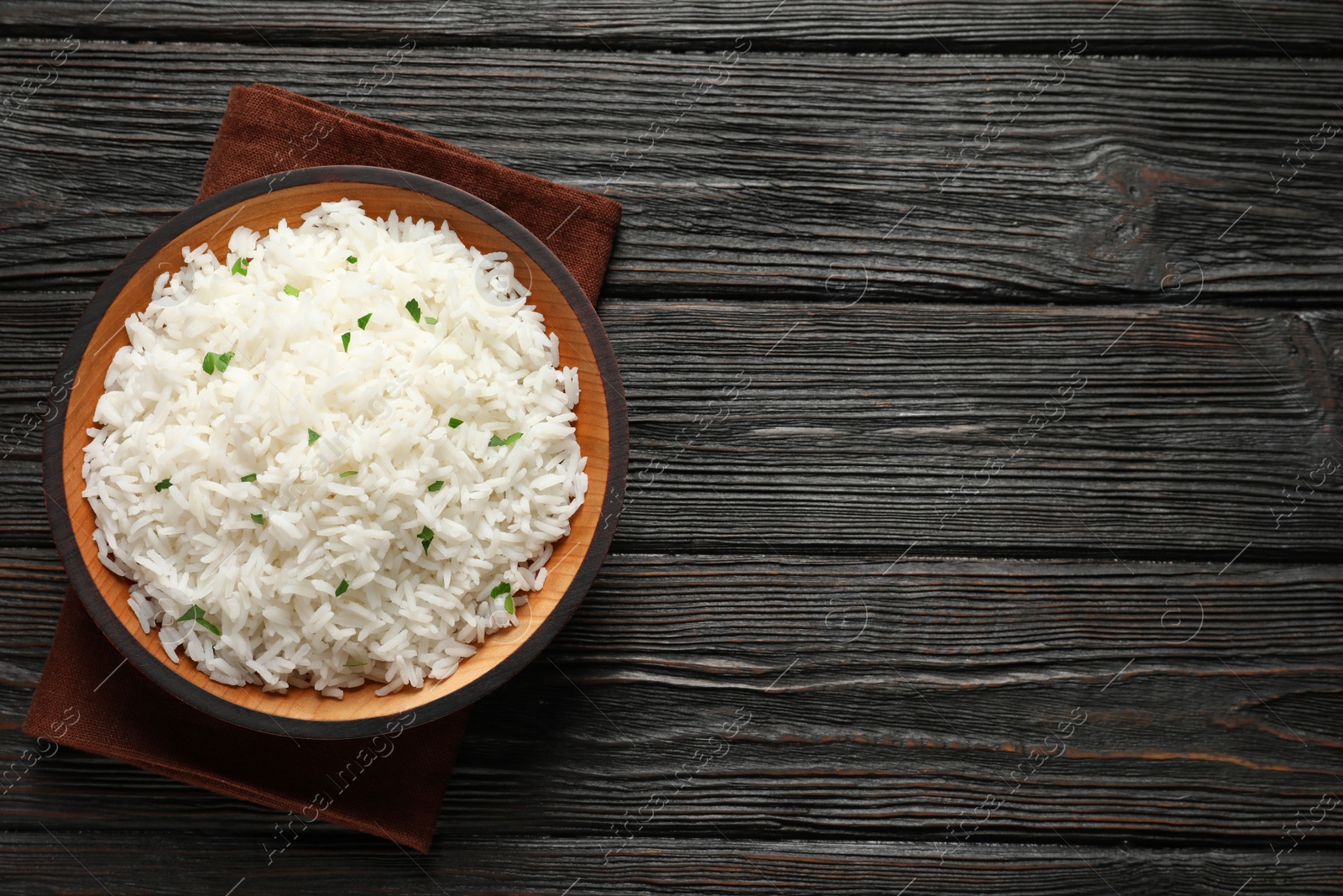 Photo of Plate of tasty cooked rice on wooden background, top view. Space for text