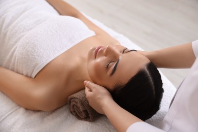 Young woman enjoying professional massage in spa salon