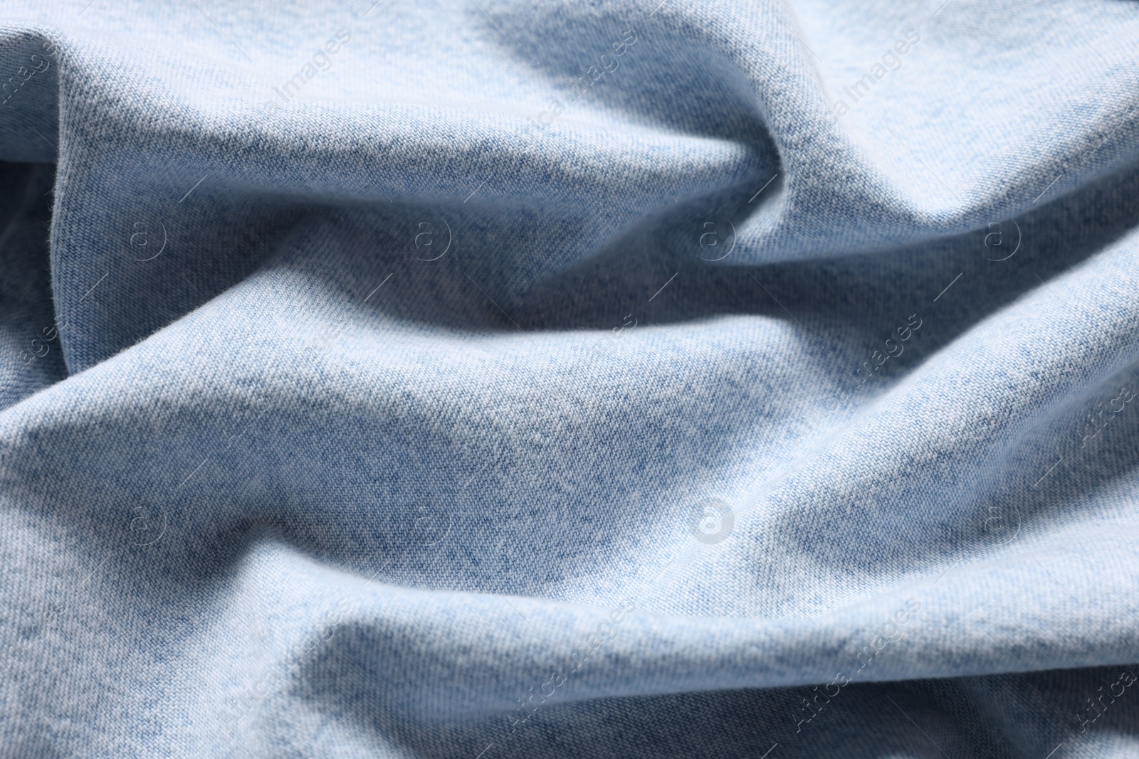 Photo of Texture of light blue crumpled fabric as background, top view