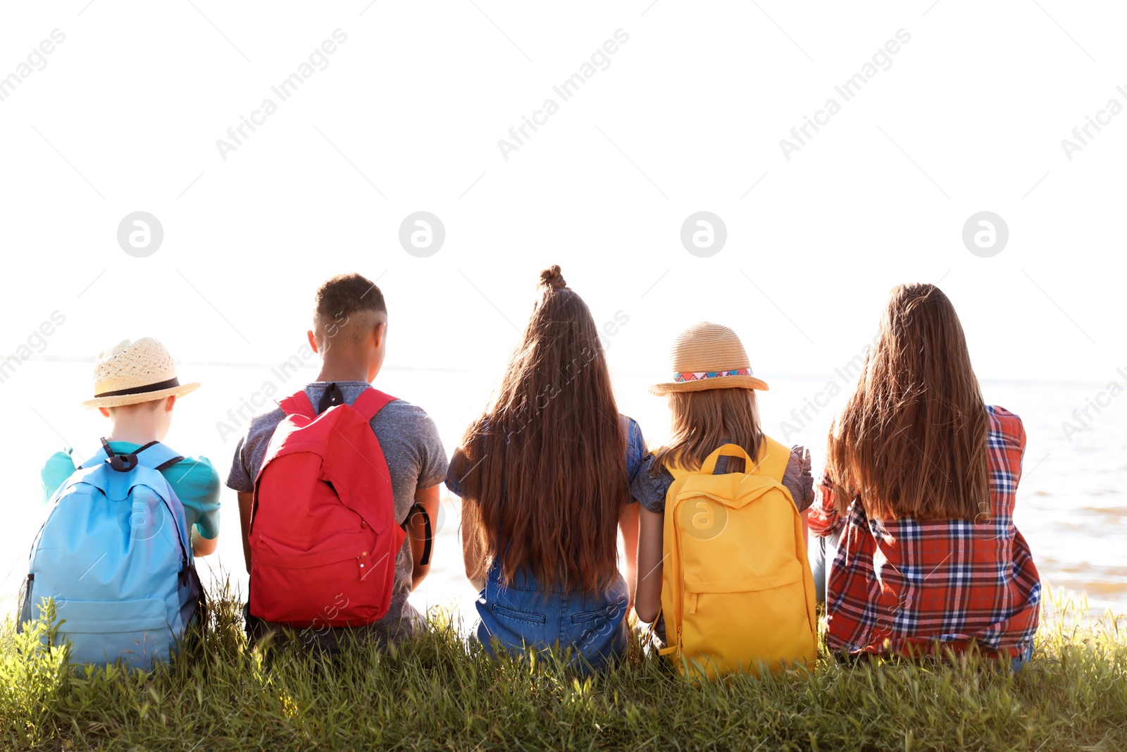 Photo of Group of children with backpacks on coast. Summer camp