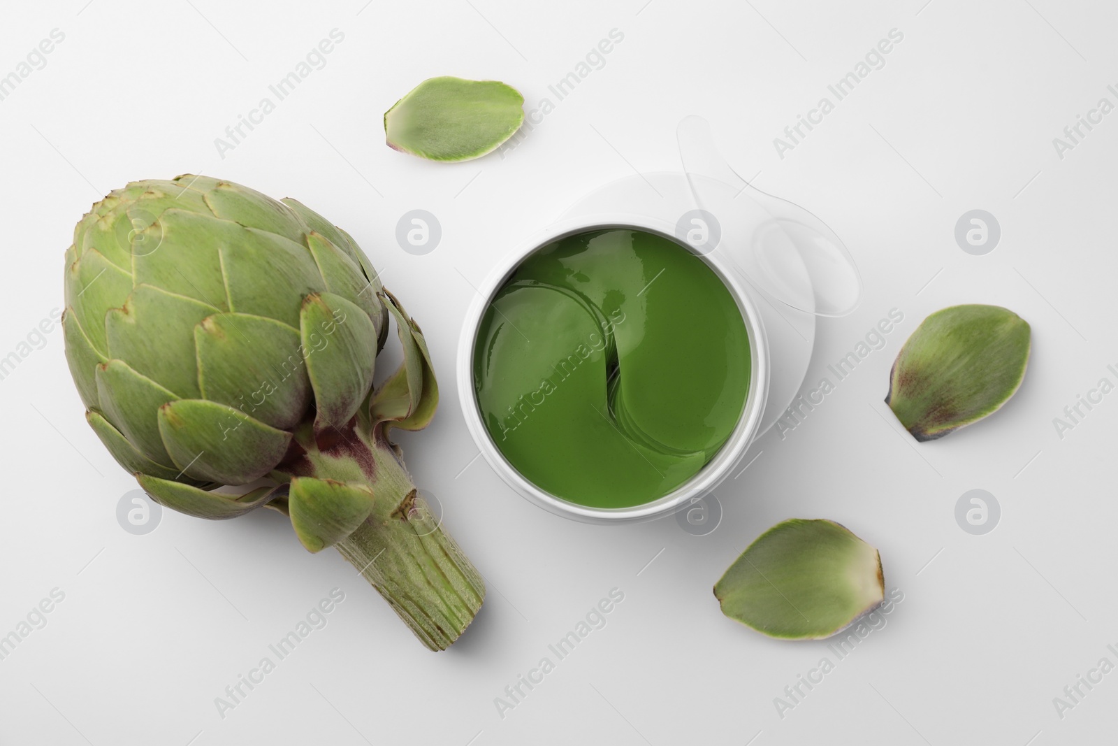 Photo of Package of under eye patches and artichokes on white background, top view. Cosmetic product