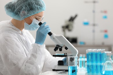 Photo of Young scientist working with microscope in laboratory