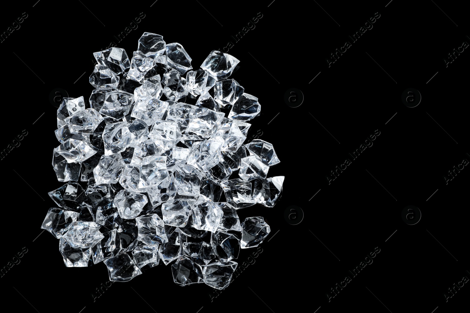 Photo of Heap of crushed ice on black table, top view. Space for text