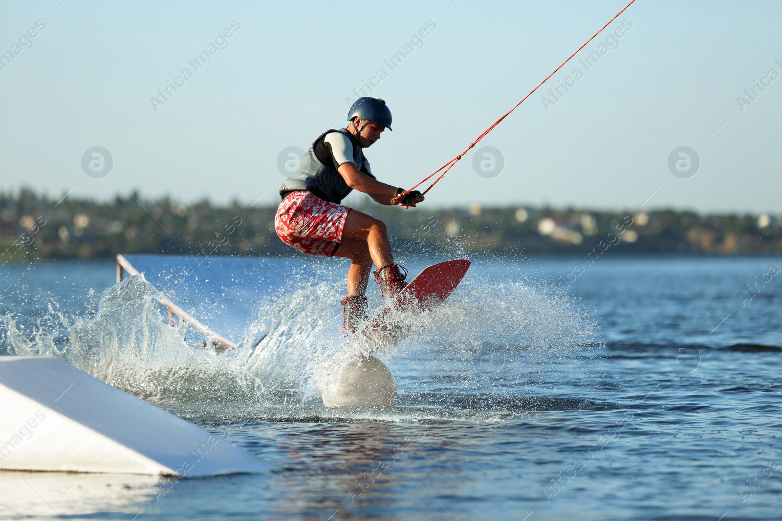 Photo of Teenage wakeboarder doing trick on river. Extreme water sport