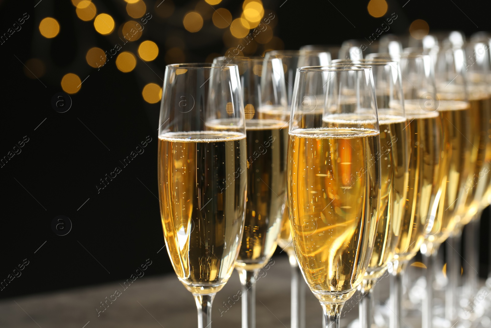 Photo of Glasses of champagne against blurred lights, closeup. Bokeh effect