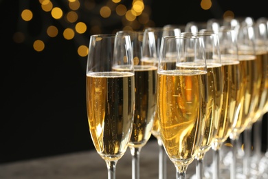 Photo of Glasses of champagne against blurred lights, closeup. Bokeh effect