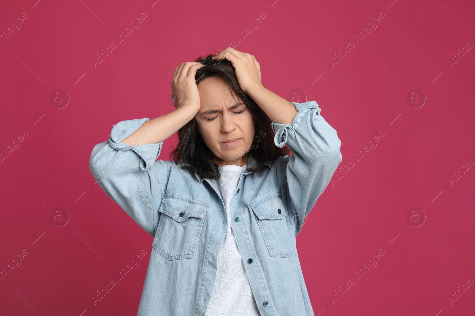 Photo of Mature woman suffering from headache on pink background