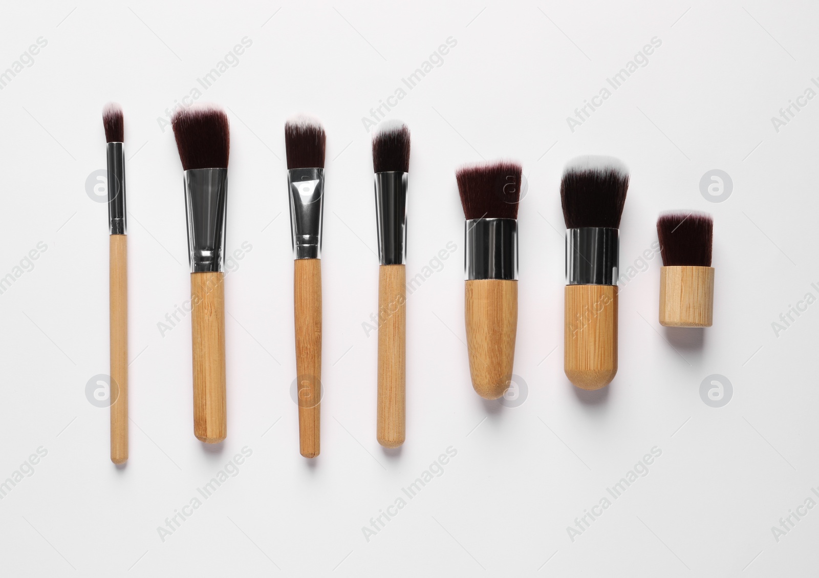 Photo of Different makeup brushes on white background, flat lay