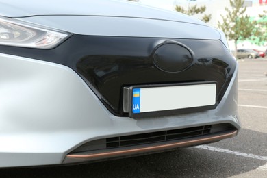 Car with vehicle registration plate outdoors, closeup