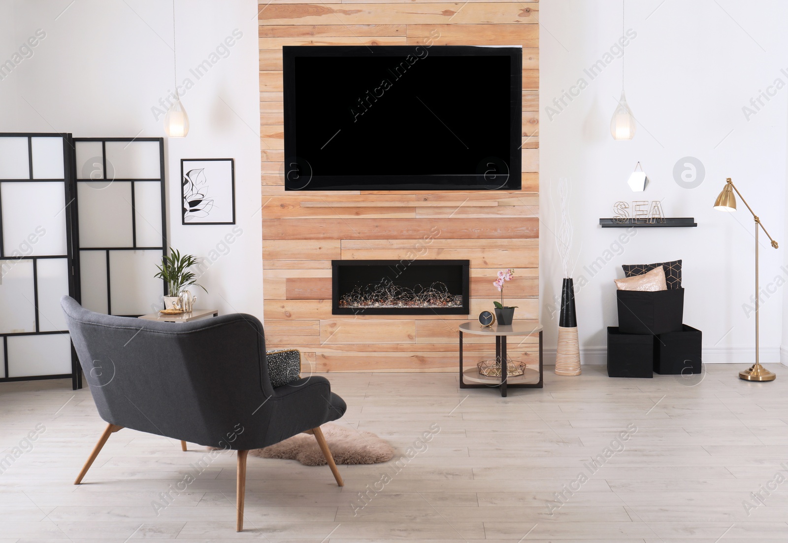 Photo of Living room interior with decorative fireplace in wooden wall