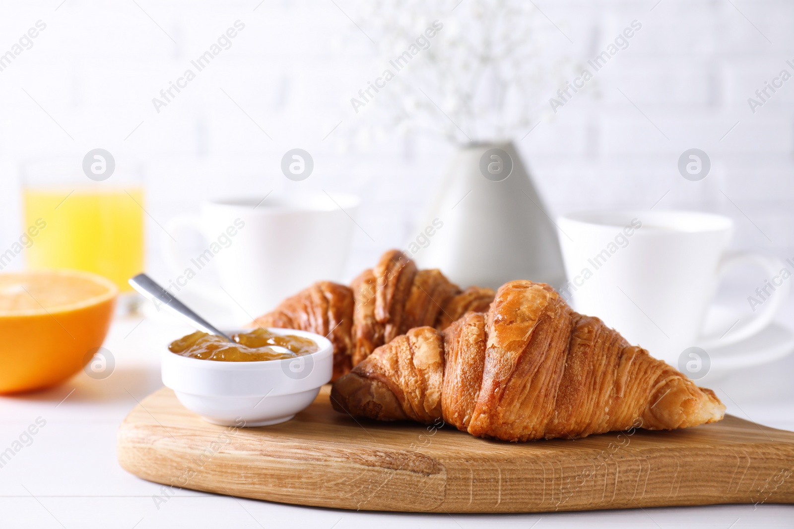 Photo of Croissants and jam on white wooden table. Tasty breakfast