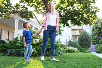 Nanny with cute little boy together on sunny day. Space for text