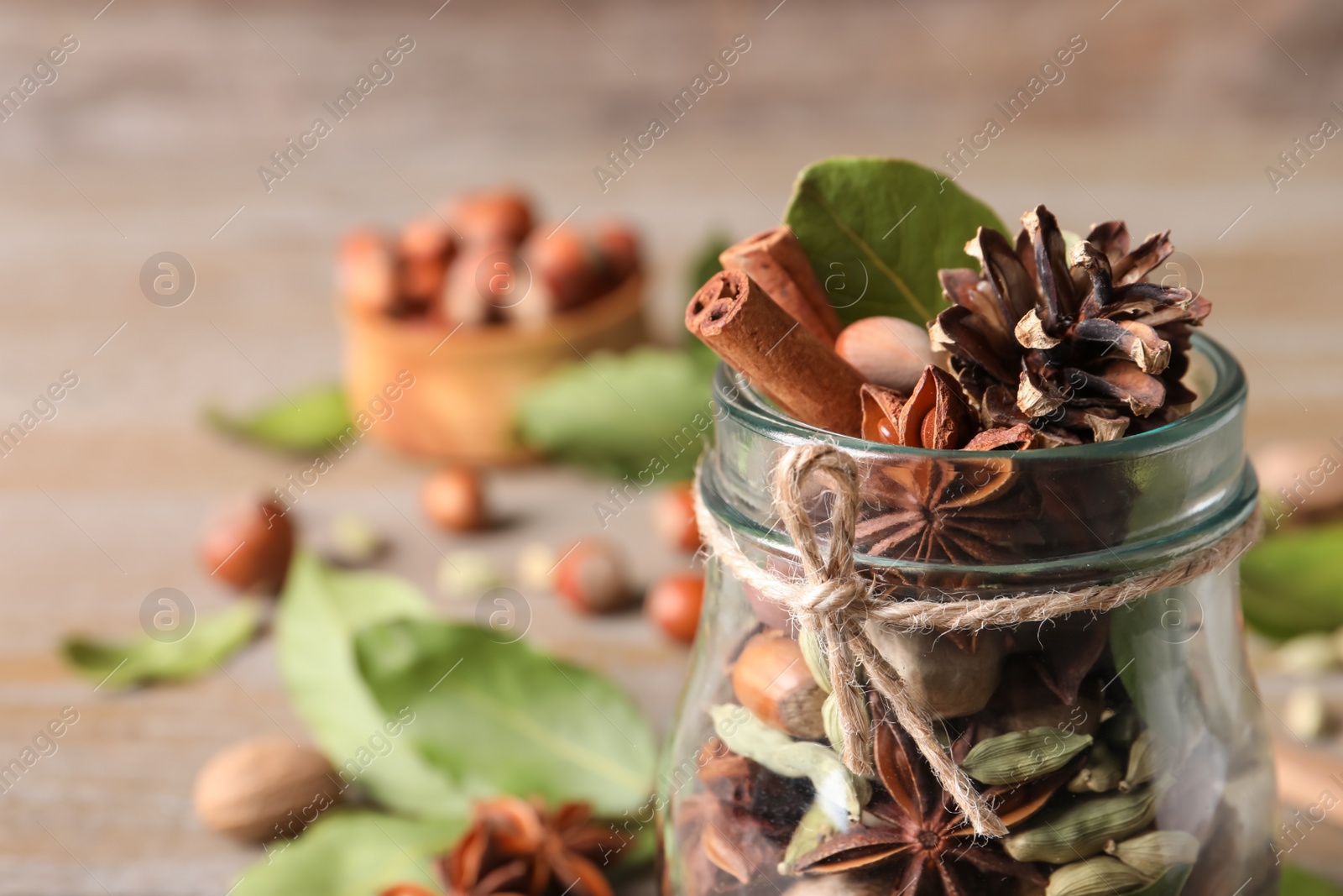 Photo of Aromatic potpourri in glass jar on table, closeup. Space for text