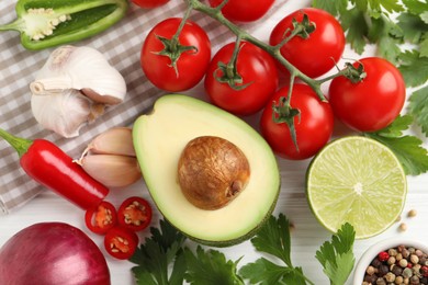 Fresh ingredients for guacamole on white wooden table, flat lay