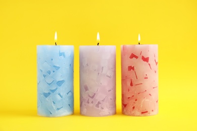 Photo of Alight scented wax candles on color background