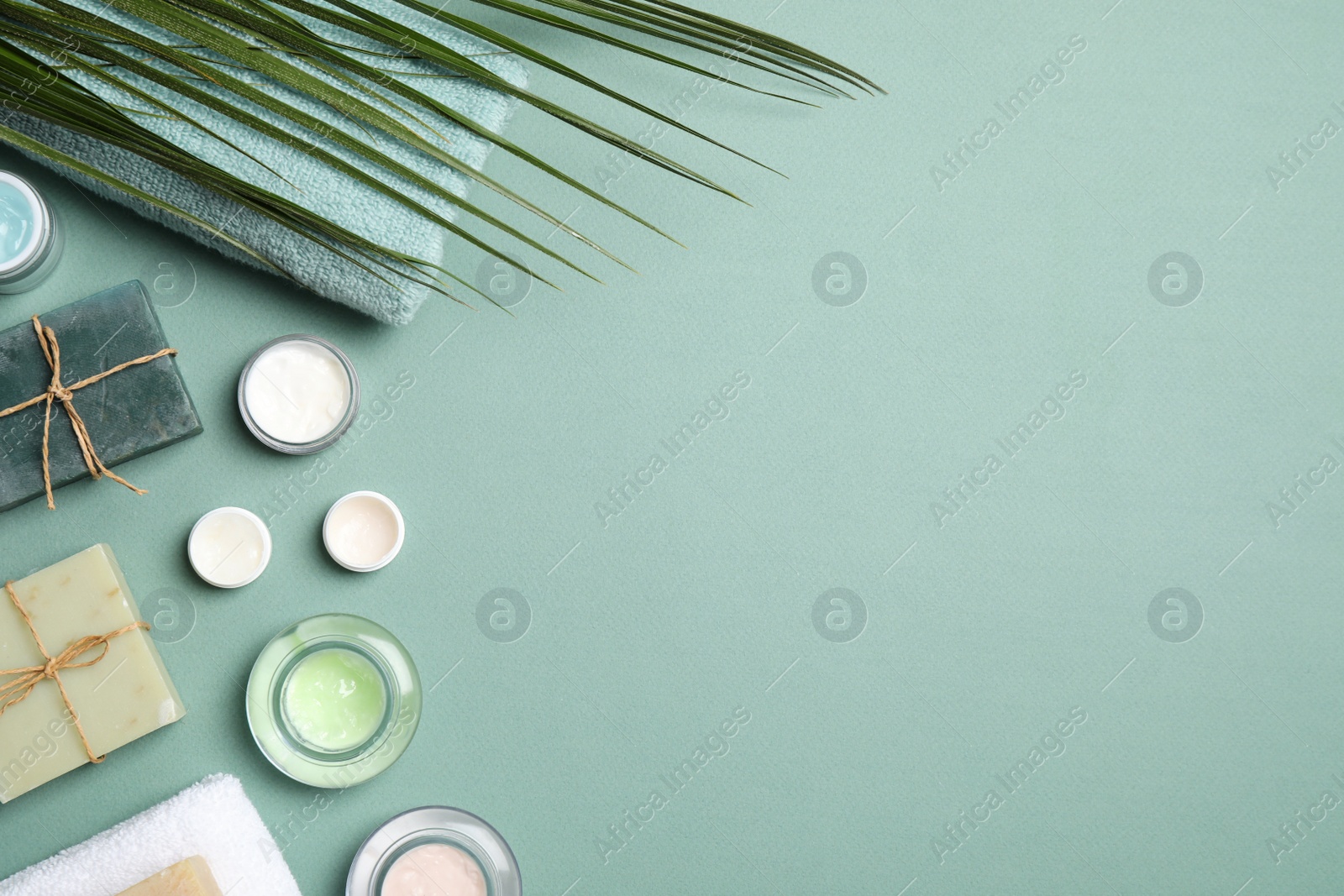 Photo of Different personal care products on teal background, flat lay. space for text