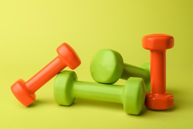 Photo of Many different stylish dumbbells on light green background