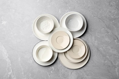 Set of clean tableware on grey table, flat lay