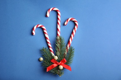 Photo of Candy canes on blue background, flat lay