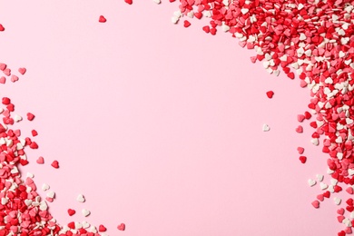 Photo of Heart shaped sprinkles on pink background, flat lay. Space for text