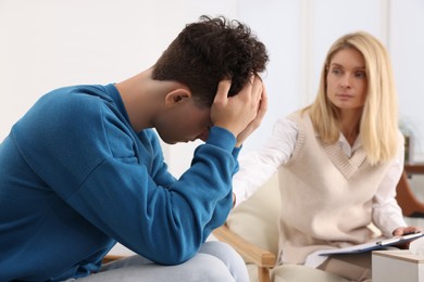 Photo of Psychologist working with teenage boy in office. Teenager problems