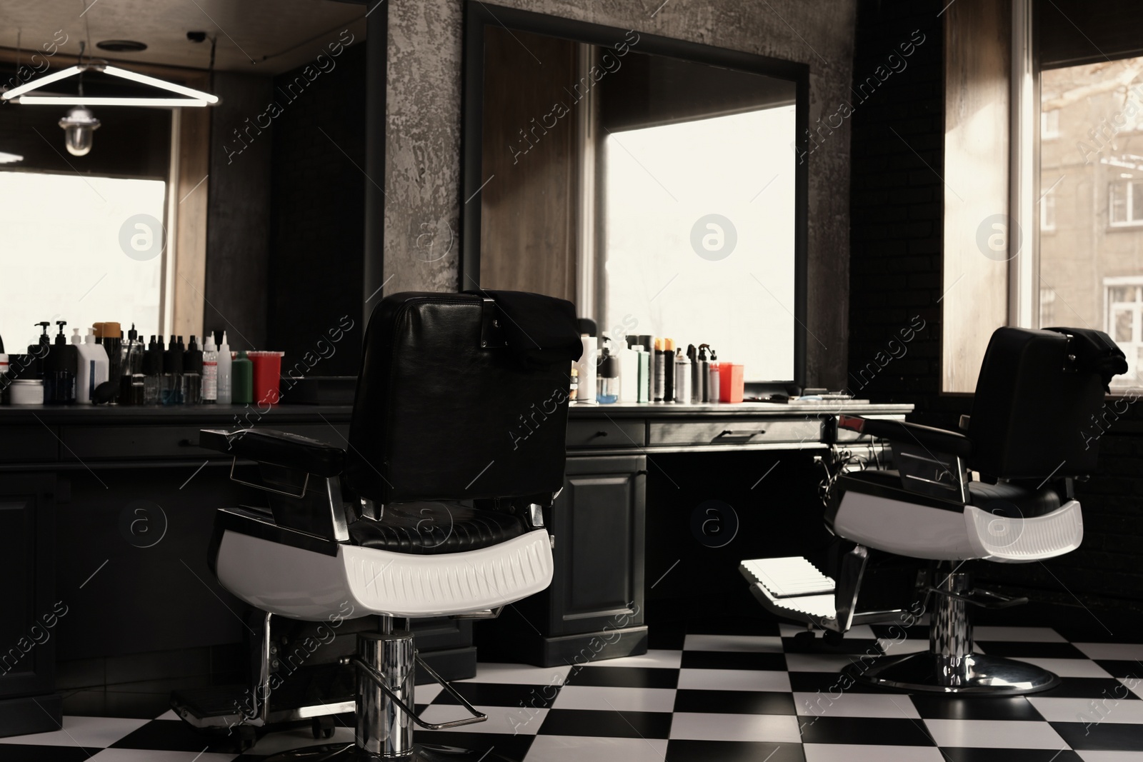 Photo of Stylish monochrome interior of modern barbershop. Equipped workplace