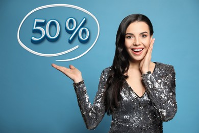 Image of Surprised woman pointing at illustration of fifty percent on light blue background. Special promotion