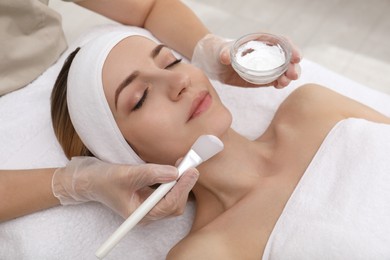 Photo of Young woman during face peeling procedure in salon