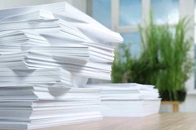 Stacks of paper sheets on wooden table indoors, closeup. Space for text