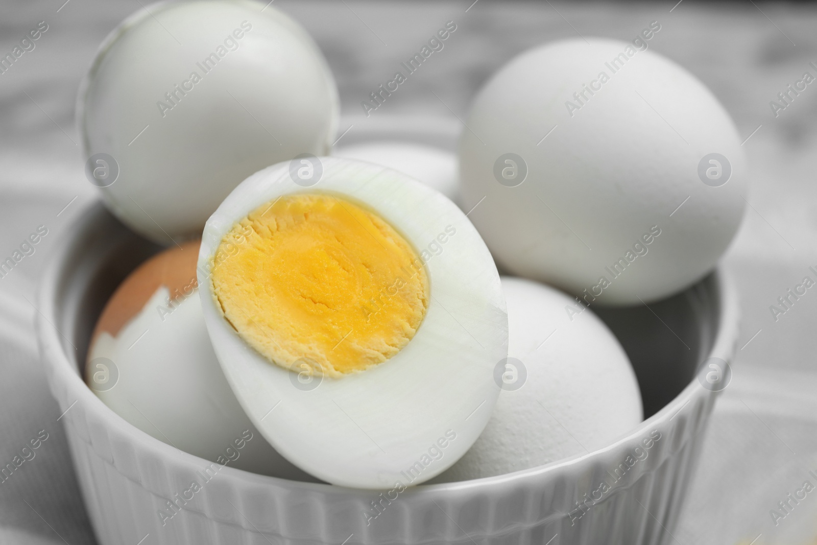 Photo of Bowl with hard boiled eggs on blurred background, closeup
