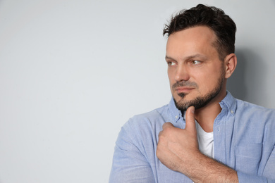 Portrait of handsome man on light grey background. Space for text