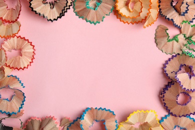 Photo of Frame made of pencil shavings on pink background, top view. Space for text