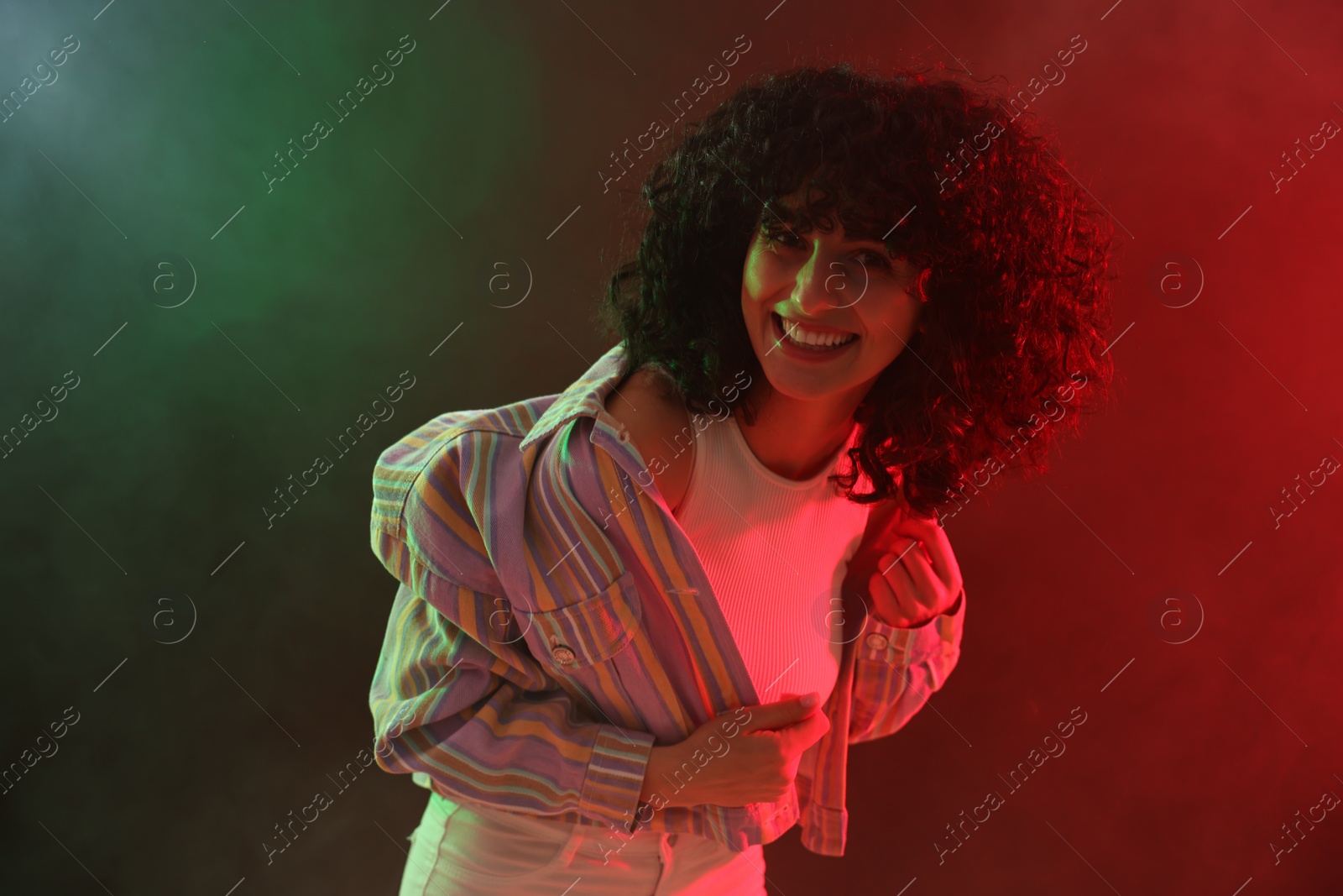 Photo of Beautiful young woman posing on color background in neon lights