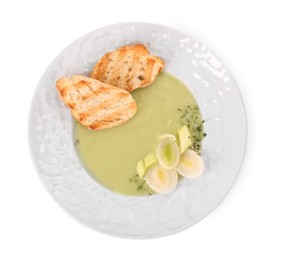 Photo of Plate of delicious leek soup with croutons isolated on white, top view