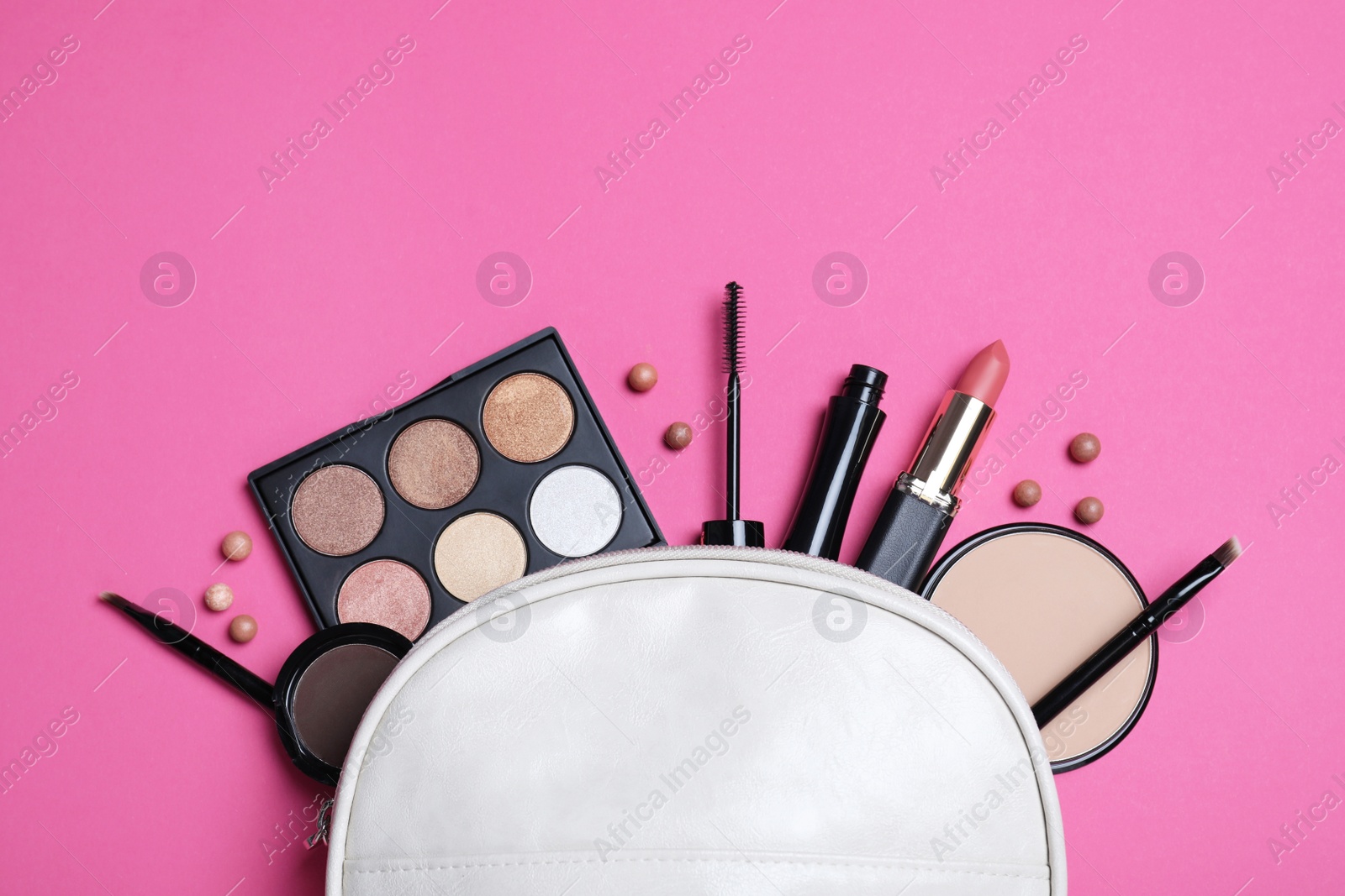 Photo of Cosmetic bag with makeup products and accessories on pink background, flat lay. Space for text